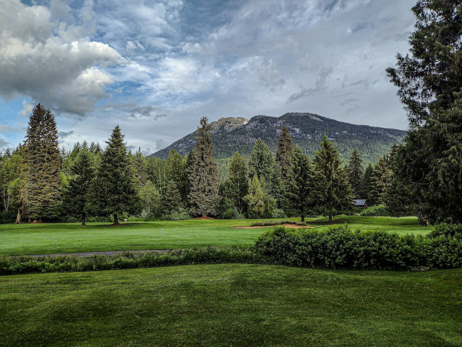 Mountain golf course fairway with peaks in the background